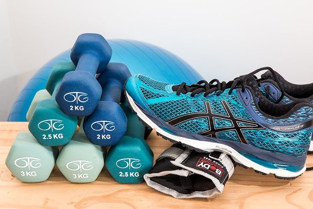Stack of dumbbells with sneakers and an exercise ball