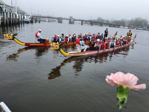 Both boats in Annapolis Harbor during the 2022 Open the Eyes of the Dragon ceremony with a pink carnation in the foreground