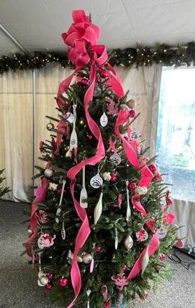 Christmas tree decorated with pink ribbons, paddles, and ADBC ornaments