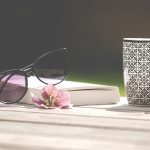 Summer reading with a book, sunglasses, flower, and mug