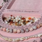 Pink craft beads on a bead board