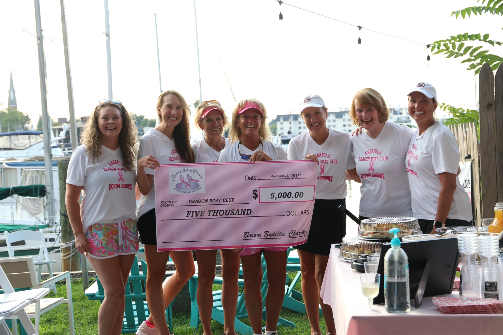 Bosom Buddies Charities presents the Annapolis Dragon Boat Club with a check for $5,000.