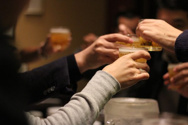 Group of friends toasting with their glasses raised and saying cheers