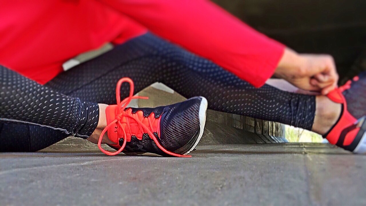 Photo of a person in fitness clothes tying their shoe