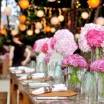 Table setting with pink flowers in vases